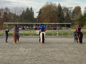 Mirrors in the arena with three riders infront of it